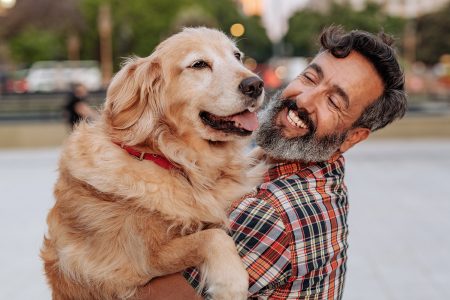 Senior Latino man hugging his senior Retriever dog Mature Latino man with beard any stylish casual clothing in springtime day in Buenos Aires, Argentina walking his Retriever dog